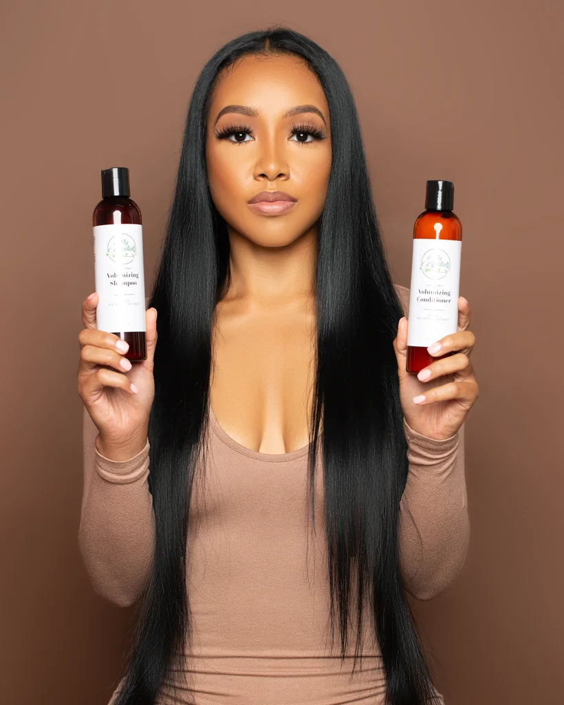 Haircare entrepreneur holding branded shampoo and conditioner products during a personal branding photoshoot