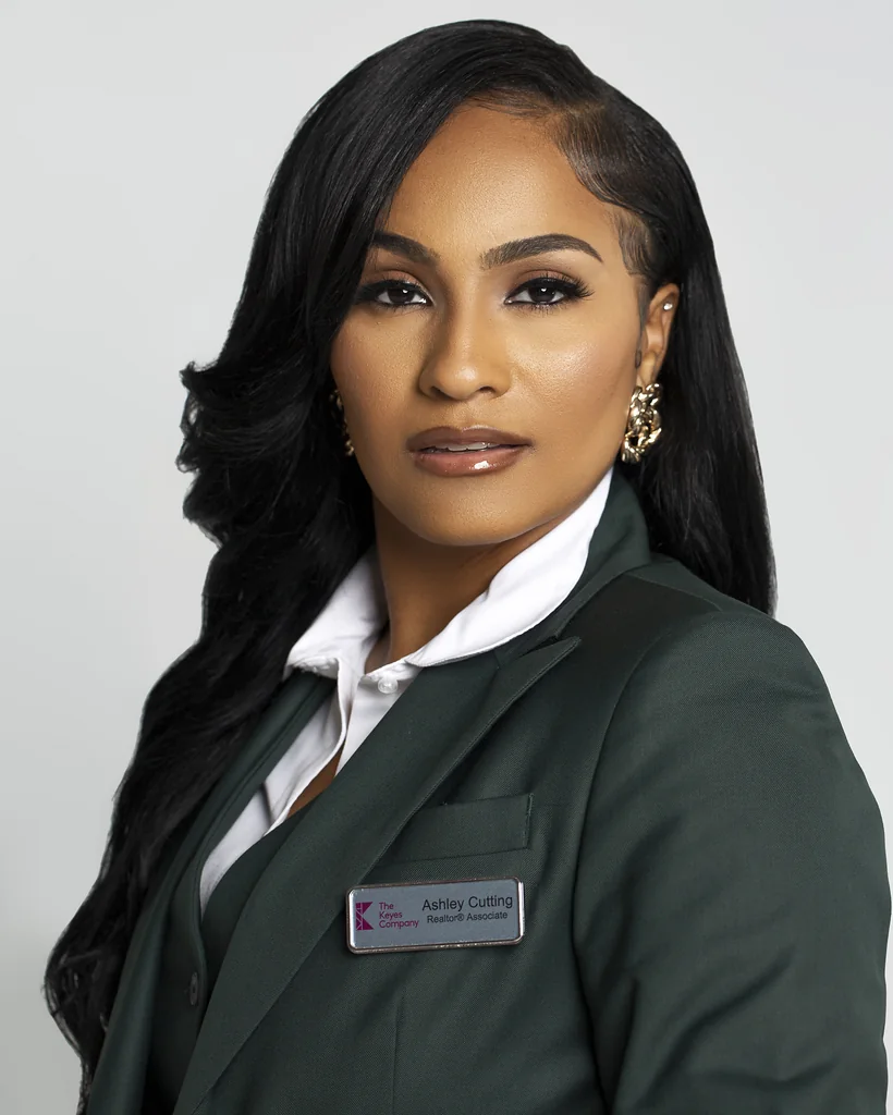 Polished real estate professional in a tailored green suit photographed for her personal brand