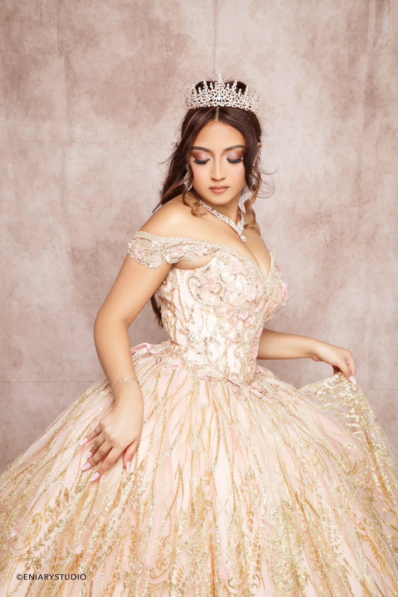 Close quinceañera portrait with crown and detailed blush gown