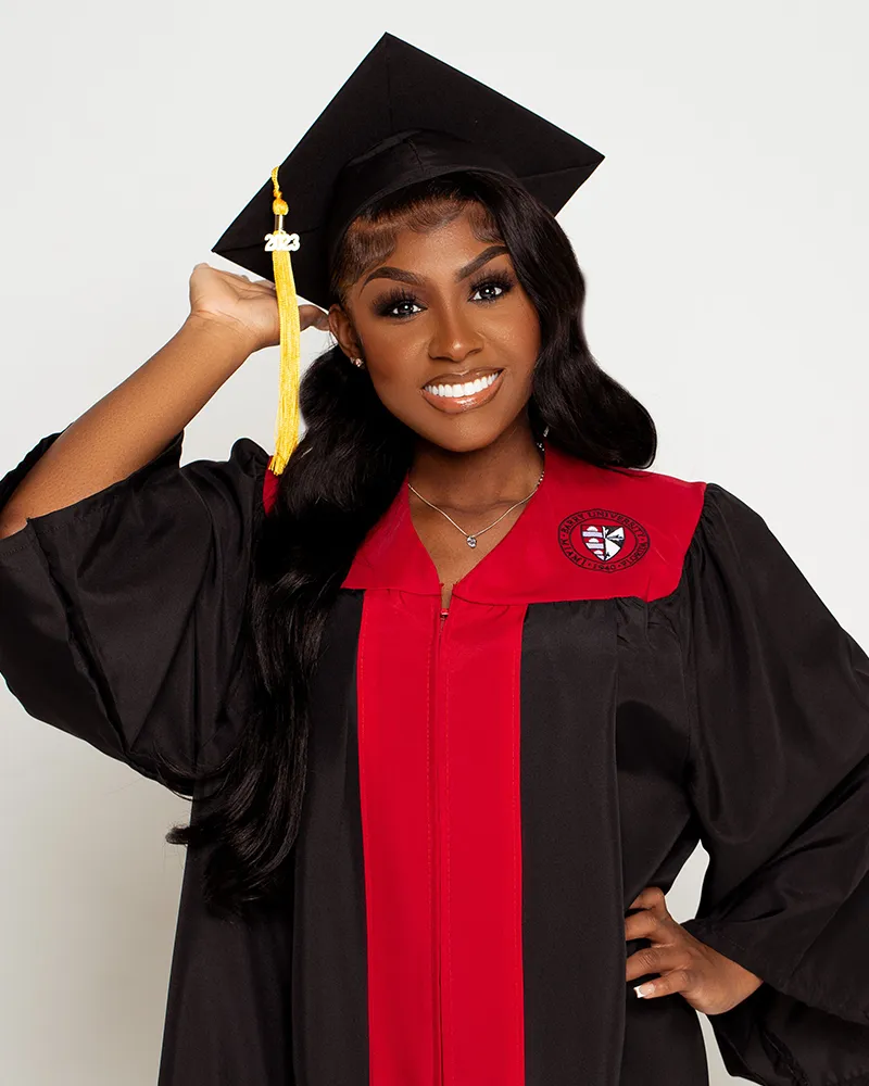 Female graduate posing in black and red cap and gown